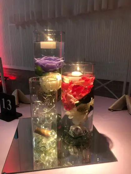 Centro de mesa com velas flutuantes e flores